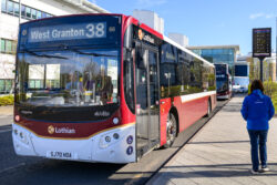 Red and white city bus at a stop, showing route 38 to Granton on the front display, with the pavement and shelter alongside.